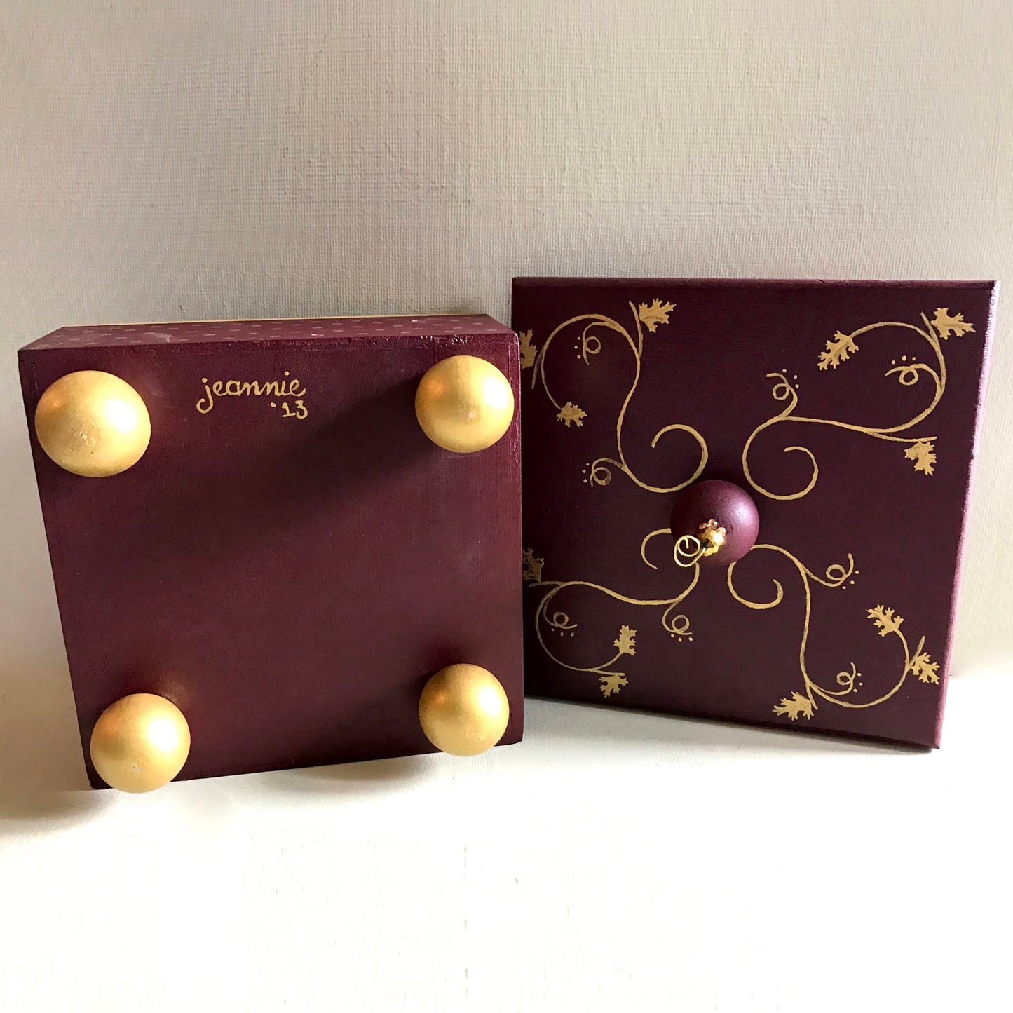 Gold leaf decorative handmade wooden box with metallic gold details showing bottom feet and lid detail.